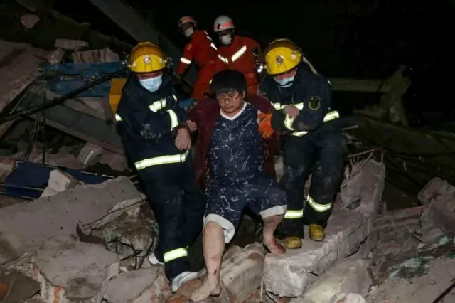 A man is helped out of the rubble of a collapsed hotel by rescuers in Quanzhou, in China"s eastern Fujian province on March 7, 2020