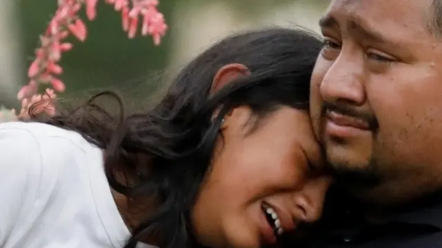 People react after the shooting outside Robb Elementary School