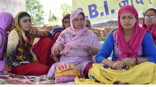 गांव में अनशन पर बैठी महिलाएं