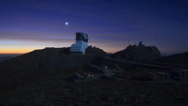 Observatório Vera Rubin ao pôr do sol, iluminado pela lua cheia