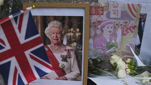 香港英国领事馆外民众摆放英女王伊丽莎白二世遗像与纪念她1975年访问香港的绘画（10/9/2022）