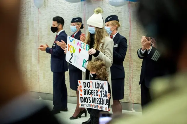 People wait for relatives after the arrival of a British Airways flight at New York's JFK International Airport