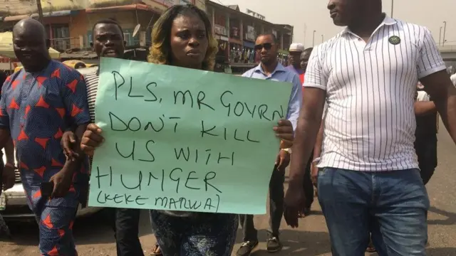 Wata mata dauke da kwali an rubuta Don Allah Mr Gwamna kar ka kashe mu da yunwa, a bar keke ya ci gaba da aiki