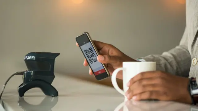 Utilisation d'un scanner pour payer par téléphone pour acheter un café dans un café