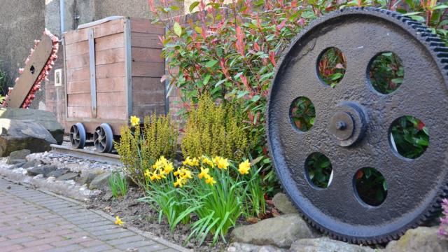 Вагонетка и колесо подъемника в саду деревни Кроссгейтс