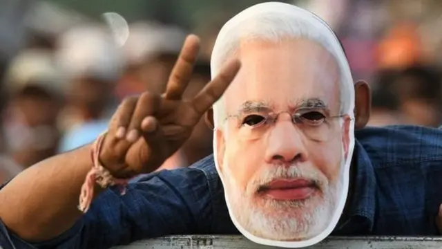 મોદીના મુખવટા સાથે વ્યક્તિ