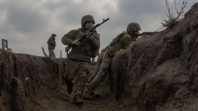 أفراد من اللواء الميكانيكي الرابع والعشرين التابع للجيش الأوكراني خلال تدريب ميداني على الخنادق في موقع لم يُكشف عنه في المنطقة الشرقية من أوكرانيا، في 18 مارس/آذار 2025، وسط الغزو الروسي لأوكرانيا.