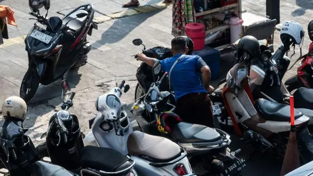 Juru parkir liar merapikan sepeda motor yang terparkir di kawasan Salemba, Jakarta, Senin (13/5/2024). 