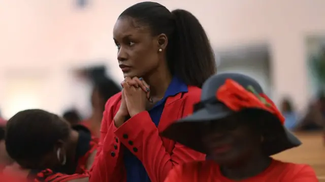 Una mujer haitiana reza en una iglesia de Miami.
