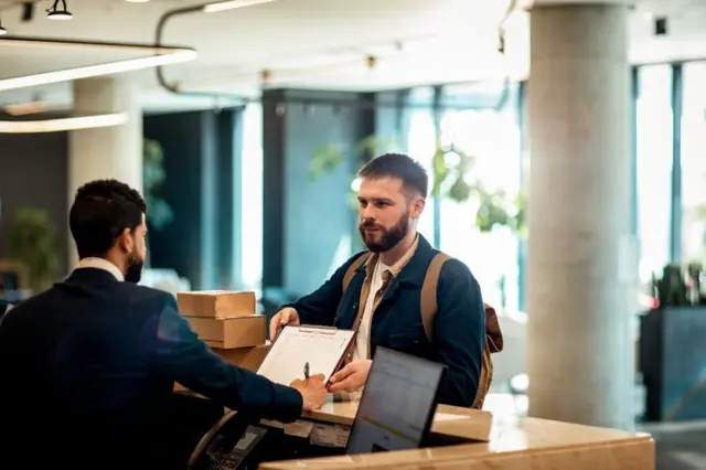 Un recepcionista de un hotel atiende a un visitante.