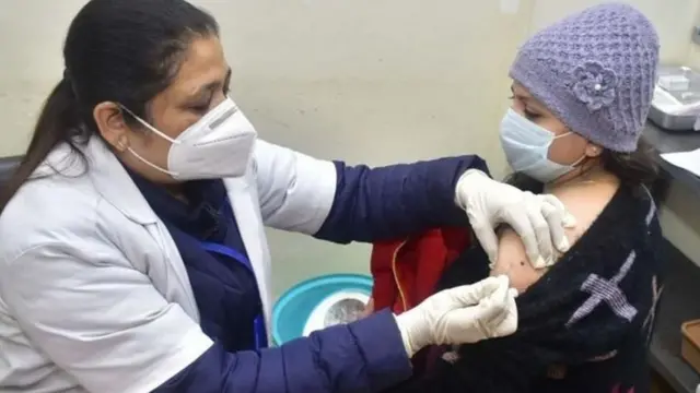 રસી મૂકી રહેલા તબીબ અને સ્વંયસેવકની તસવીર