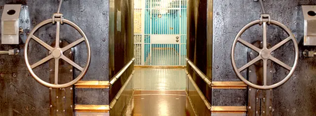 Acceso a la Bóveda del Oro, un pasillo angosto a cuyos lados se aprecian dos grandes manivelas. 