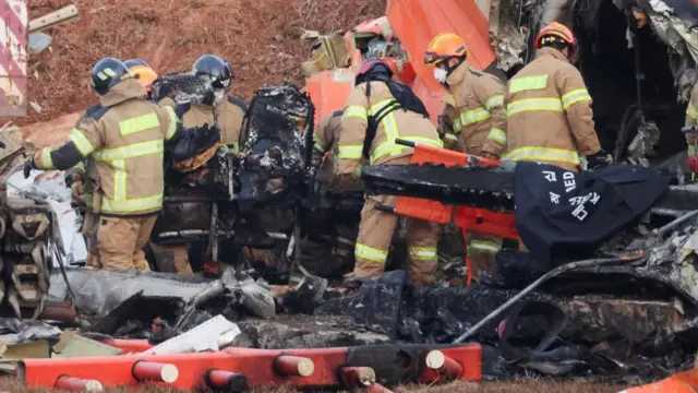 事故機の中から焼けたシートを搬出する作業が続いた