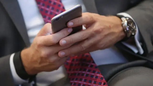 ఐఫోన్ ఉపయోగిస్తున్న వ్యక్తి