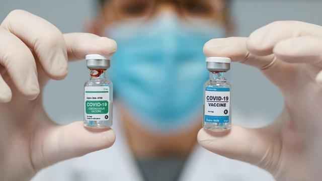 Médica mostrando dos opciones de vacuna contra el coronavirus