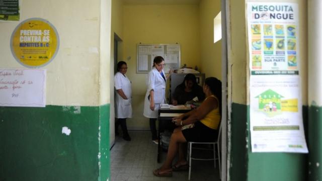 Profissionais de saúde e paciente dentro de clínica de saúde da família na Baixada Fluminense, RJ