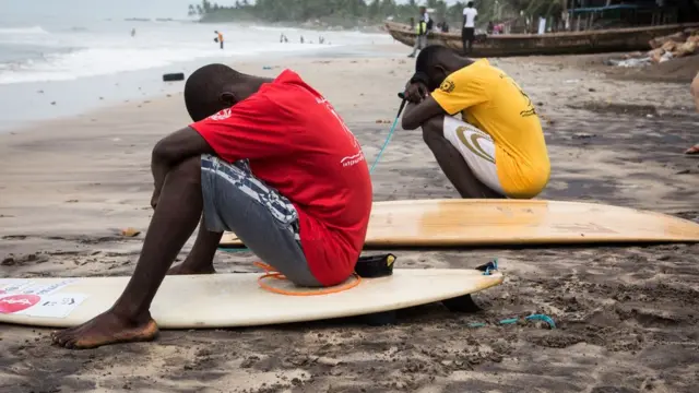 Awọn ọdọ meji joko wọn dorikodo ni bebe okun