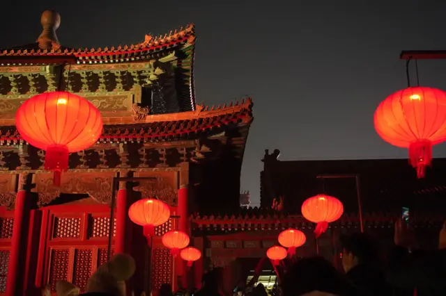 城墙上红色灯笼随风摇曳，节日气氛随处可见。
