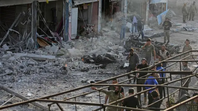 Turkey-backed Syrian fighters inspect the site of a car bomb explosion in the northern Syrian Kurdish town of Tal Abyad, on the border with Turkey, on November 2, 2019.