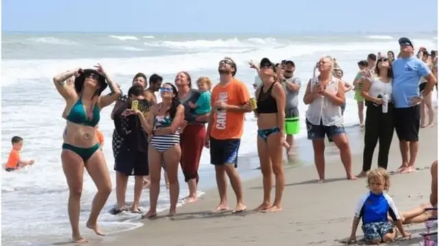 సముద్ర తీరాల నుంచి వీక్షిస్తున్న ప్రజలు