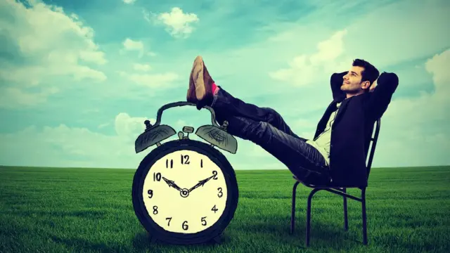 Hombre descansando con los pies sobre un reloj.