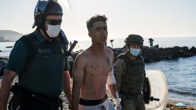 Un migrante siendo trasladado por las autoridades.