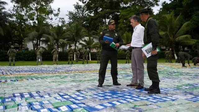 El presidente de Colombia, José Manuel Santos, junto a la policía encargada de la operación mostrando parte de la cocaína incautada.