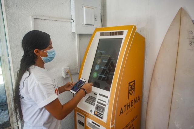Una mujer retira efectivo de una ATM de bitcoins.