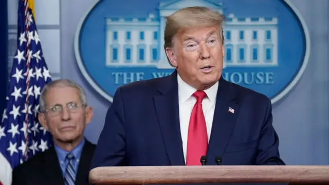 الرئيس الأمريكي دونالد ترامب ويبدو خلفه الطبيب أنتوني فاوتشي