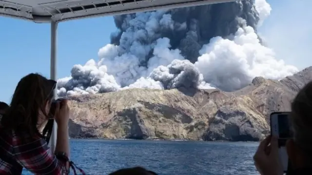 Seorang turis mengabadikan letusan gunung Pulau Putih.