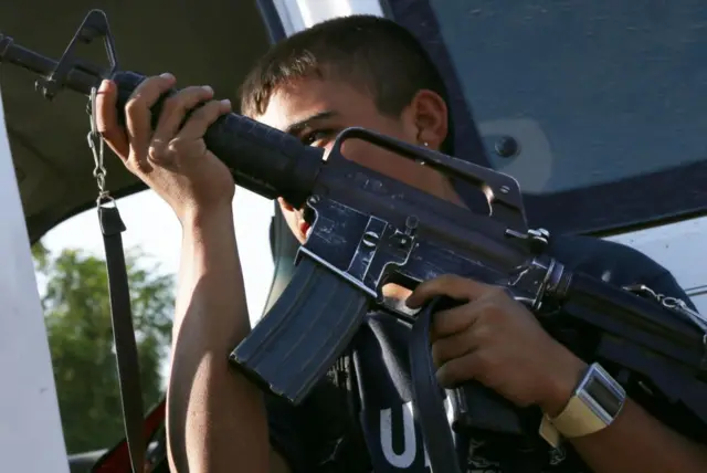 Un hombre sostiene un rifle de alto poder
