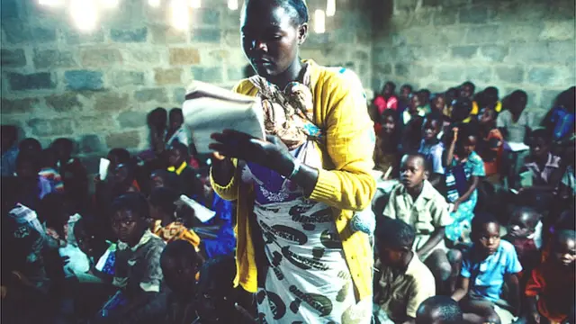 Olukọ kan duro, o n kọ awọn akẹkọ