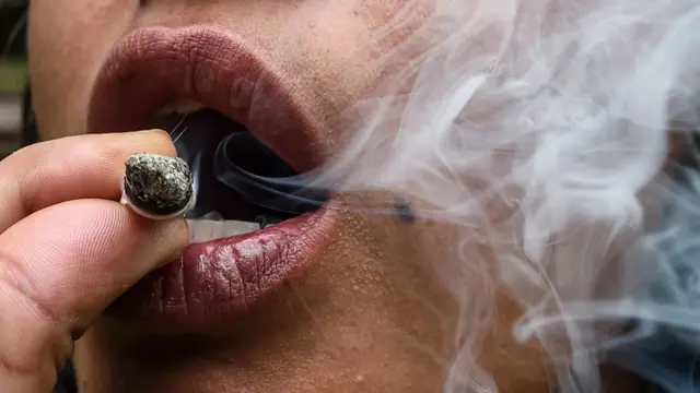 Mujer fumando marihuana.