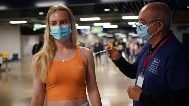 Maisie Ayres, aged 18, receives a Pfizer BioNTech COVID-19 vaccine at an NHS Vaccination Clinic at Tottenham Hotspur"s stadium in north London.