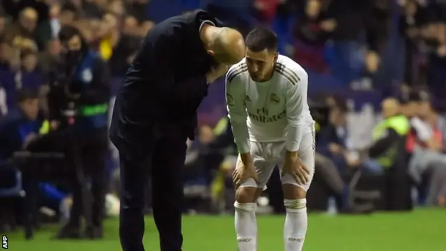 Zinedine Zidane speaks to Eden Hazard after he comes off injured against Levante