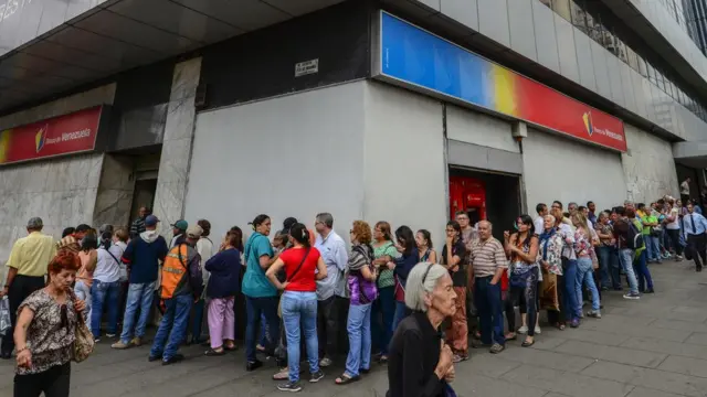 Una fila de gente frente a un banco