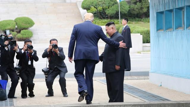 US President Donald Trump steps into North Korea next to Kim Jong-un (30 June 2019)