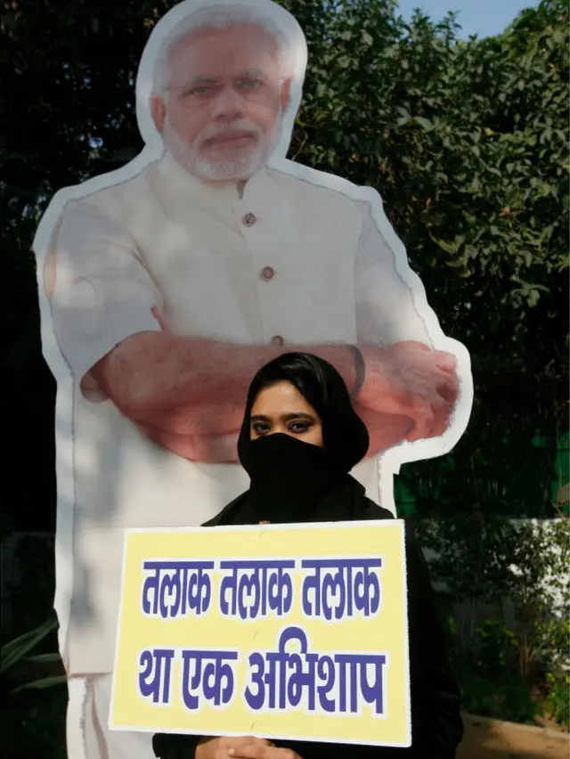 નરેન્દ્ર મોદીના પોસ્ટર પાસે ઊભેલી મુસ્લિમ મહિલા