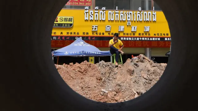 柬埔寨西哈努克(西港)一位男士坐在一家商店門前眺望建築工地(資料圖片)