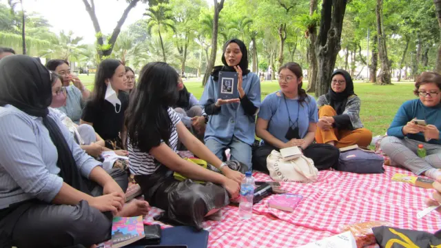 Orang-orang berkumpul membaca buku