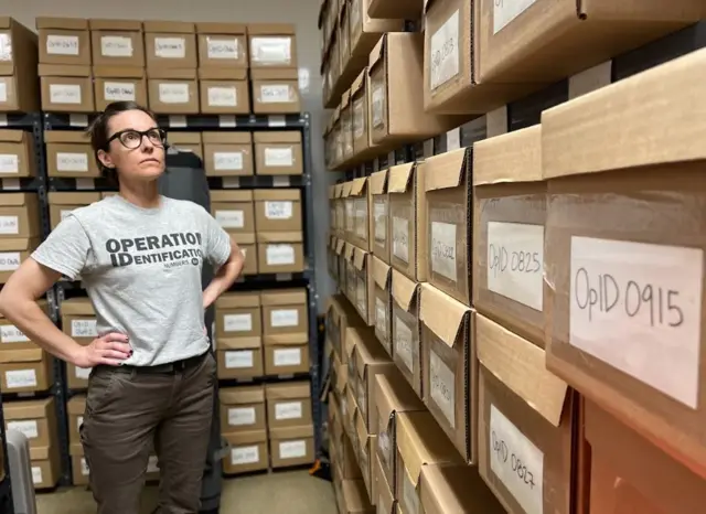 Kate Spradley con cajas en las que hay restos de migrantes fallecidos, en el laboratorio de Operation Identification en San Marcos, Texas, el 24 de abril de 2024.