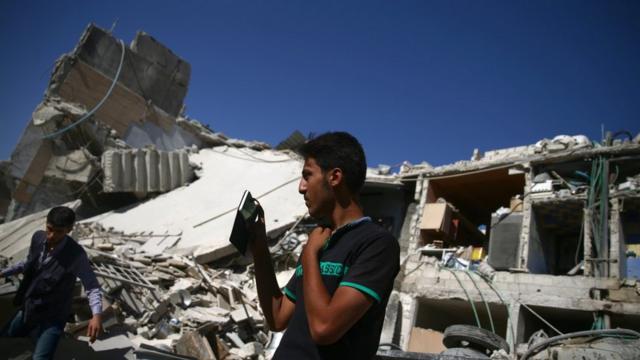 Homem tira foto dos destroços resultantesmrjack betum ataquemrjack betDamasco com seu celular