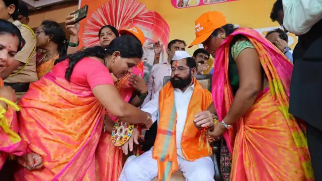 लाडकी बहीण योजनेच्या कार्यक्रमात महिलांकडून राखी बांधून घेताना मुख्यमंत्री एकनाथ शिंदे 