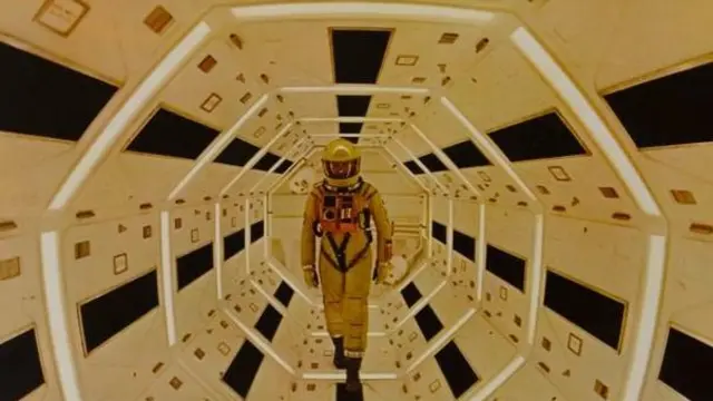 صحنه‌ای از فیلم «۲۰۰۱: یک ادیسه فضایی» مردی با لباس فضانوردی در حال راه رفتن درون یک سفینه