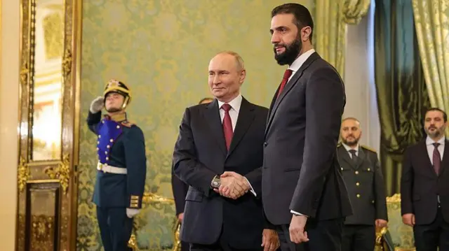 Российский президент Владимир Путин жмет руку временному президенту Сирии Ахмеду аш-Шараа