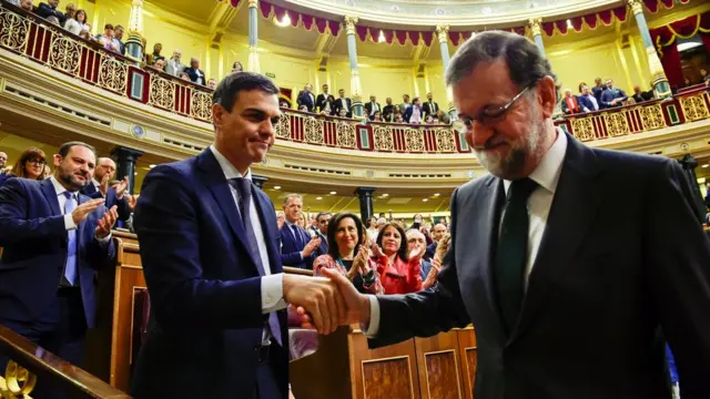 Spain"s new Prime Minister and Socialist party (PSOE) leader Pedro Sanchez shakes hands with ousted Prime Minister Mariano Rajoy after a motion of no confidence vote at parliament
