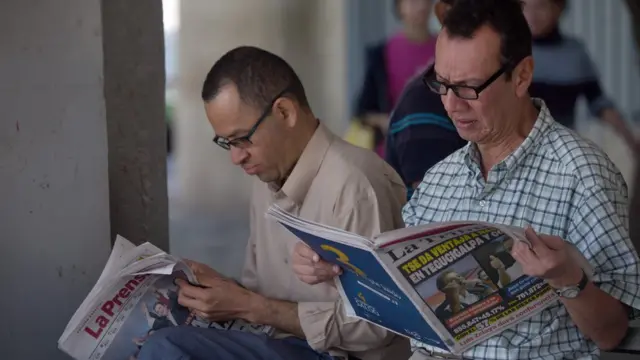 Hondureños leyendo la prensa en Tegucigalpa.