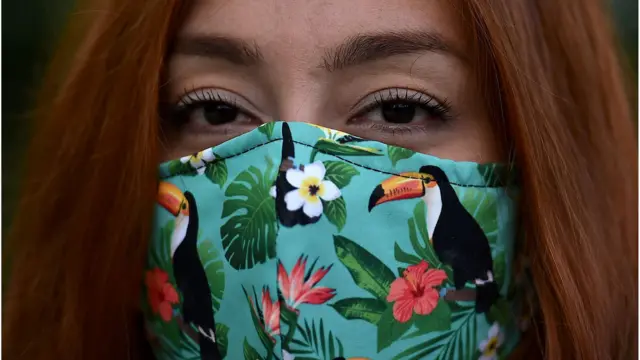 A woman wears a face mask as a preventive measure against the spread of the novel coronavirus, COVID-19, at zoo in Cali, Colombia, on June 21, 2020