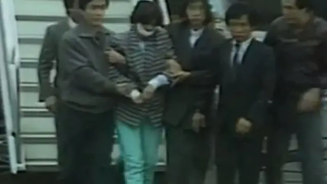 Kim Hyun-hui presa descendo do avião