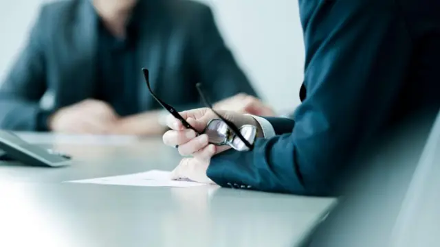 مقابلة عمل ومدير ينظر في سيرة ذاتية لأحد المرشحين